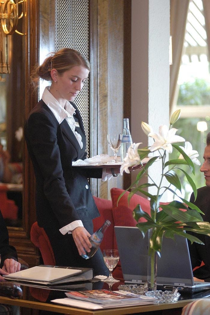 Kellenerin - Service - Restaurant - Tisch - Mineralwasse - Reiner Pfister - klein